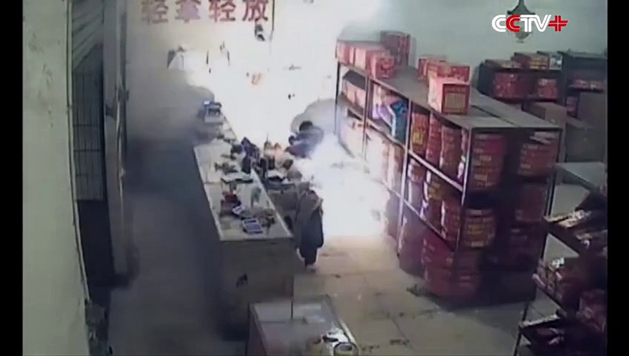 Un homme allume des pétards devant une boutique de feux d'artifice