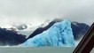 Retournement d'un énorme Iceberg dans l'eau devant un bateau de touristes