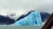 Retournement d'un énorme Iceberg dans l'eau devant un bateau de touristes