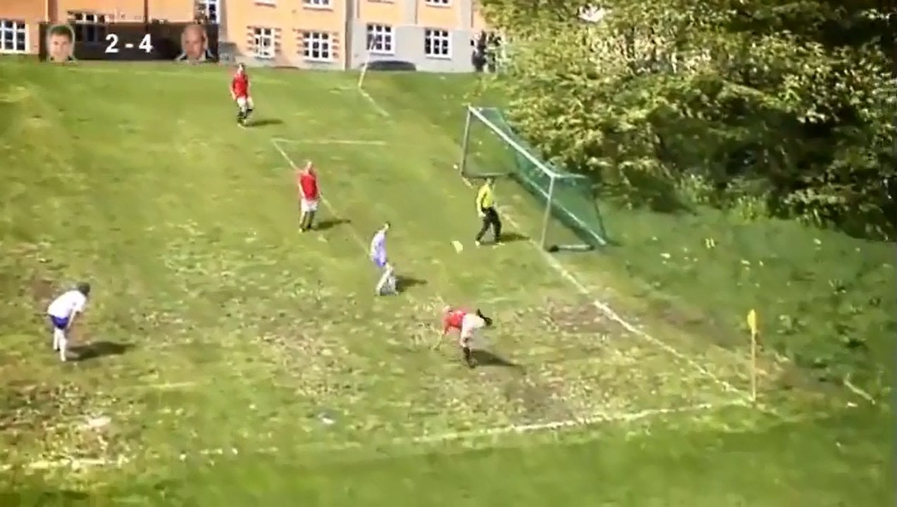 Ils font un match de foot sur un terrain en pente.