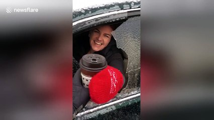 Woman punches through ice sheet to grab drink from car