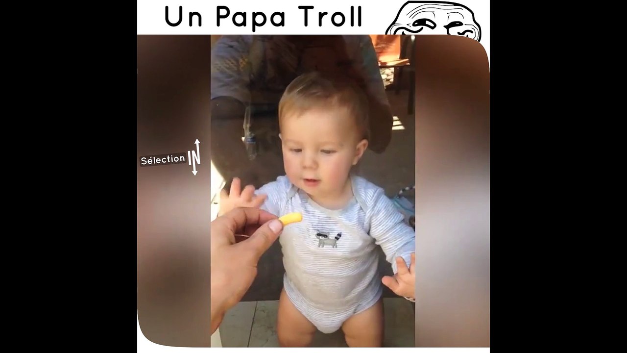 Un père trolle son enfant avec une frite derrière une vitre