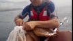 Une tortue de mer piégée dans un filet demande de l'aide à un touriste