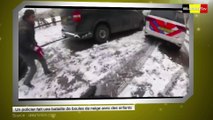 Un policier fait une bataille de boules de neige avec des enfants