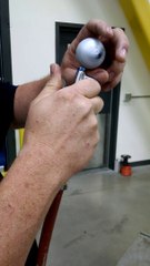 Il fait la toupie dans sa main avec une balle de golf avec un compresseur à air