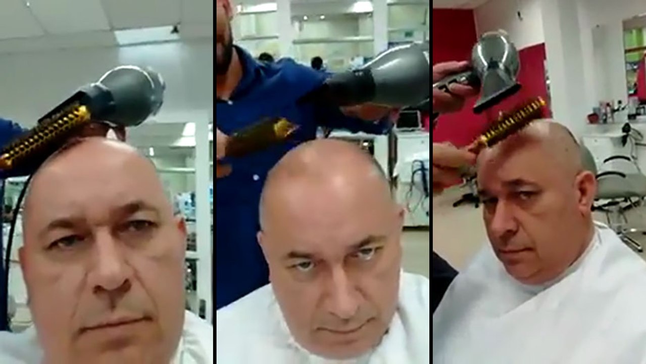 Un homme chauve fait un brushing chez le coiffeur