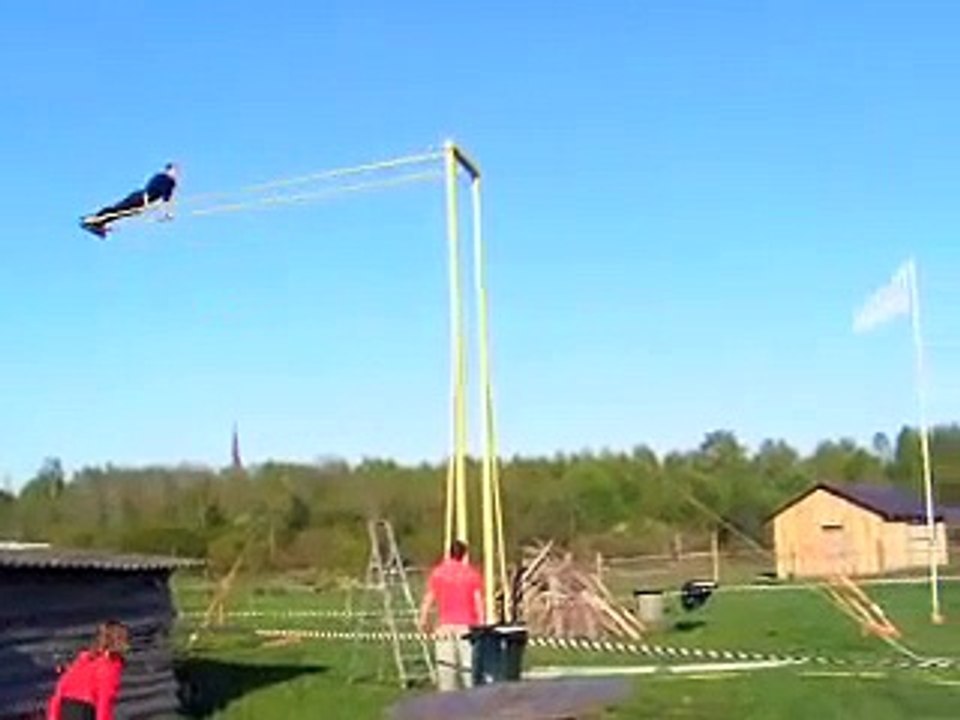 Un homme essaye de faire un tour complet sur une balançoire géante