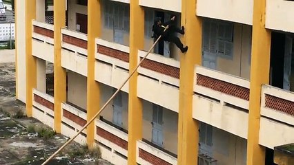 La police vietnamienne a une technique unique pour escalader les murs avec un bambou