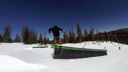 Un skieur pousse un enfant qui passe devant lui sur un tremplin