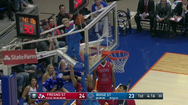 Un enfant aide des basketteurs à décoincer un ballon