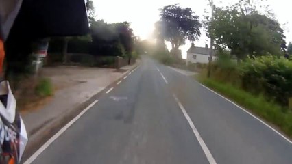 Ce motard chute et se prend un panneau en bord de route