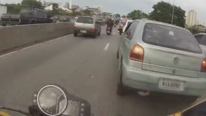 Un motard distrait par une vieille coccinelle..