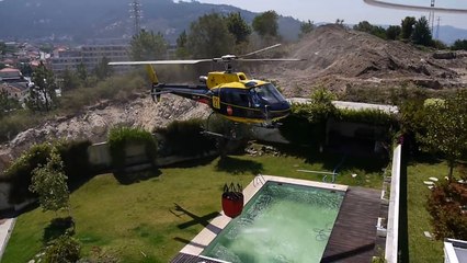 Amazing helicopter pilot taking water from swimming pool