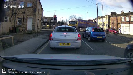 Lorry rear door almost hits car stopped at traffic light