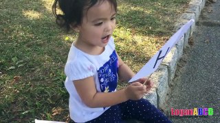 Toddler learning ABC Alphabets on a White Flags _ Fun outdoors park-nQaIsXvJ