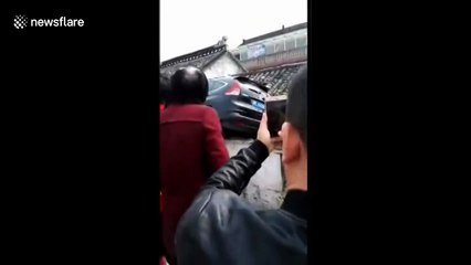 Out-of-control car crashes onto house roof