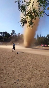 Une mini tornade de poussière se crée au milieu d'un terrain de foot en plein match