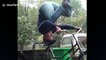 Chinese martial artist rides bike while doing a head stand