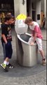 Un garçon tombe dans une poubelle métallique