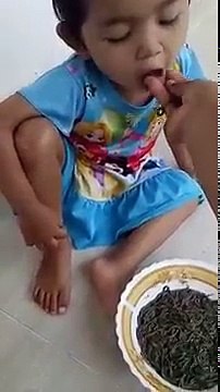 Une mère nourrit sa fille avec des vers marins