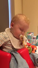 Tired baby falls asleep at dinner table