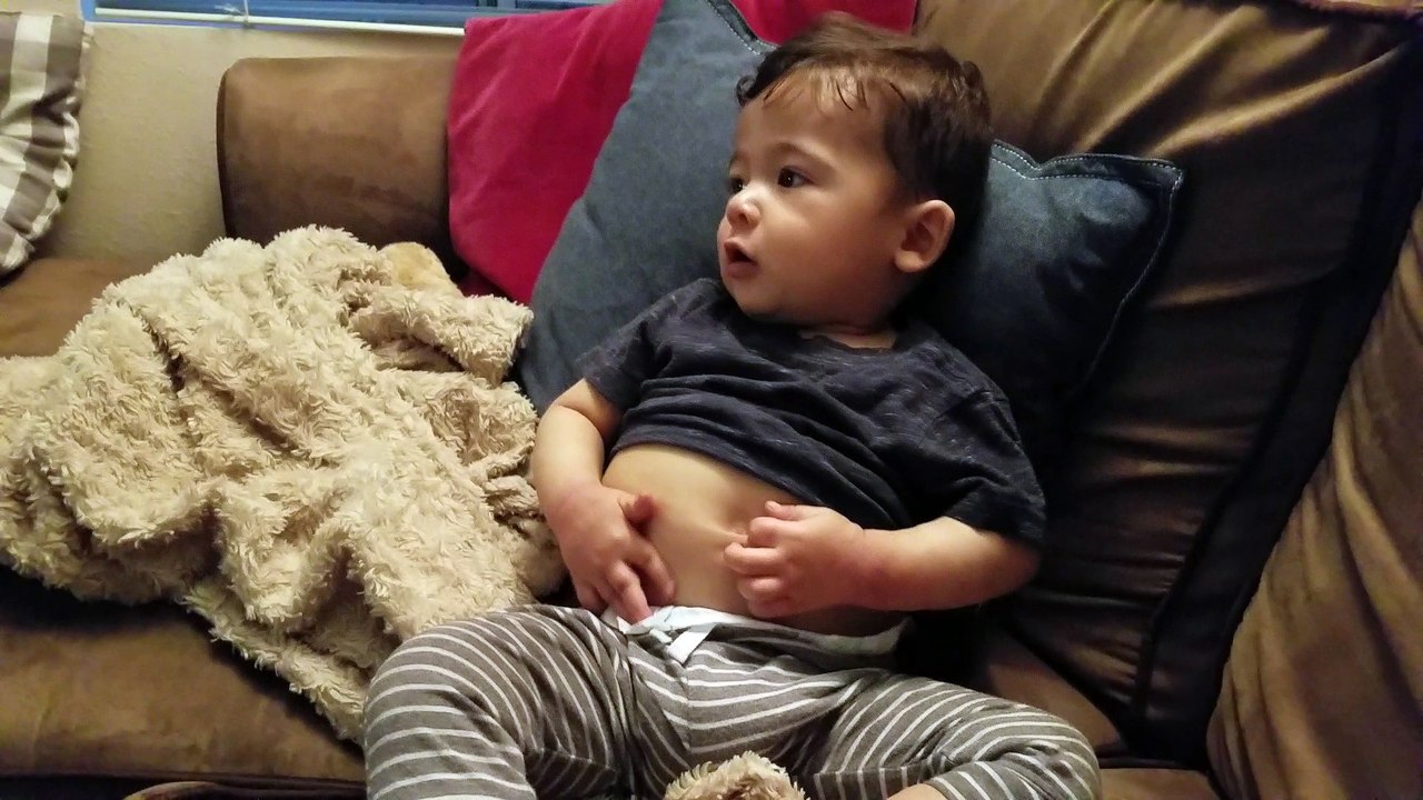 Adorable baby has fun finding his bellly button