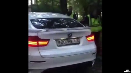 Un policier russe tente en vain de casser une vitre de BMW avec son arme