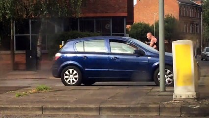 Un mec fou frappe sur le pare brise d'une voiture à mains nues !