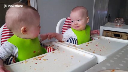 Twin babies enjoy 'chatting' over a meal