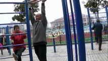 Elderly fitness master shows off skills on public fitness equipment