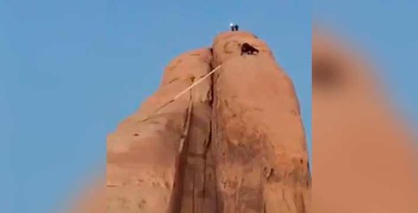Saudi fire fighters rescuing goats that got stuck in a high big Rocky Mountain
