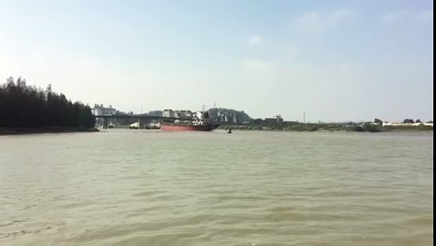 Régis passe sous un pont avec son bateau cargo