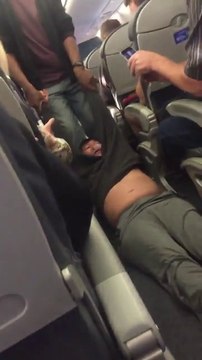Un passager trainé de force en dehors d'un avion de ligne