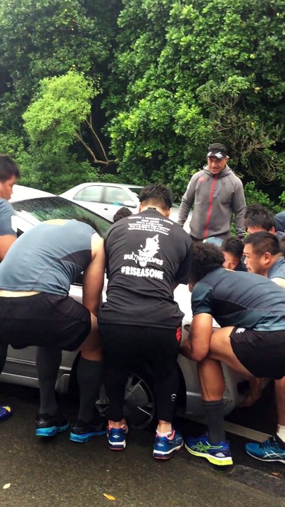 Des rugbymans viennent en aide à un homme et soulèvent sa voiture accidentée