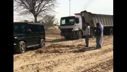 Deux 4x4 pour tracter un camion embourbé dans le sable à Dubaï.