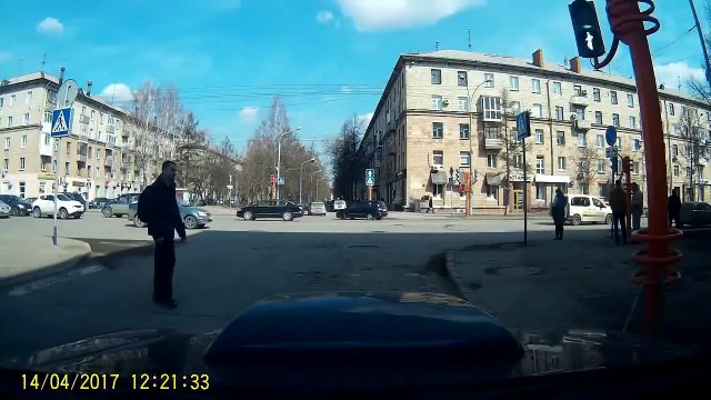 Un piéton redresse un feu de signalisation