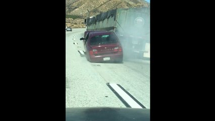 Un camion roule avec une voiture accrochée à sa remorque