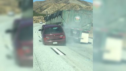 Скачать видео: Un camion roule avec une voiture accrochée à sa remorque