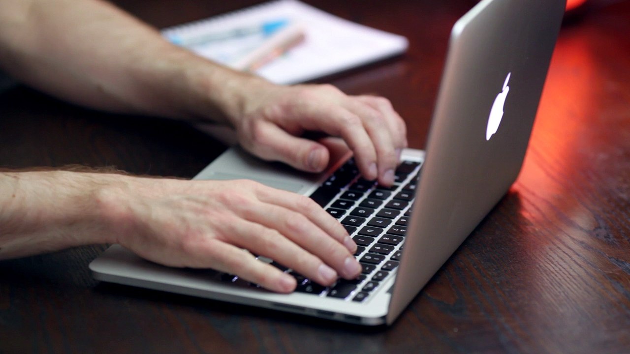 Mann beim arbeiten am Aplle iMac