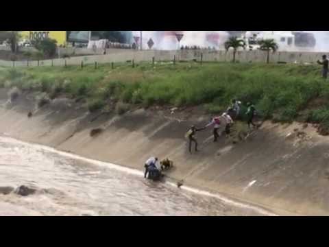 Caracas Protesters Form Human Chain to Pull Injured Man From River