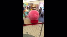 Marche d'un enfant dans une peluche géante Kirby