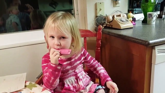 Le duo le plus adorable la fillette à l'harmonica et le chien au chant