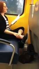 Una donna sul treno sta leggendo un libro... mentre si mangia letteralmente un piede!
