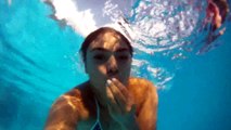 100 girls swimming underwater in pool