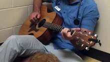 Veterinário toca e canta para acalmar cadela antes de uma cirurgia