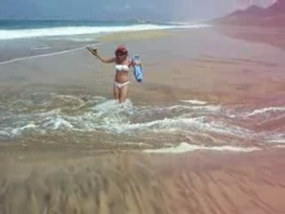 Kath traverse un torrent sur la plage
