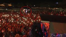 En plein concert, un rappeur fait un immense saut au milieu du public.