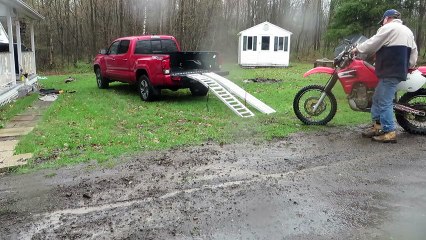 Chargement d'une moto dans la benne d'un pickup