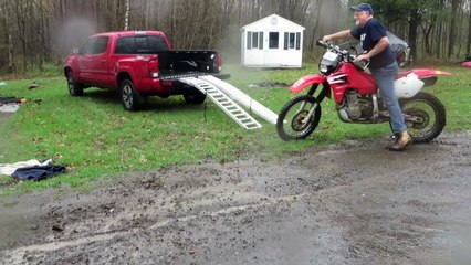 Un homme tente de mettre sa moto dans son pick up !