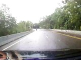 Ce motard passe à deux doigts de se faire découper par la benne d'un camion.